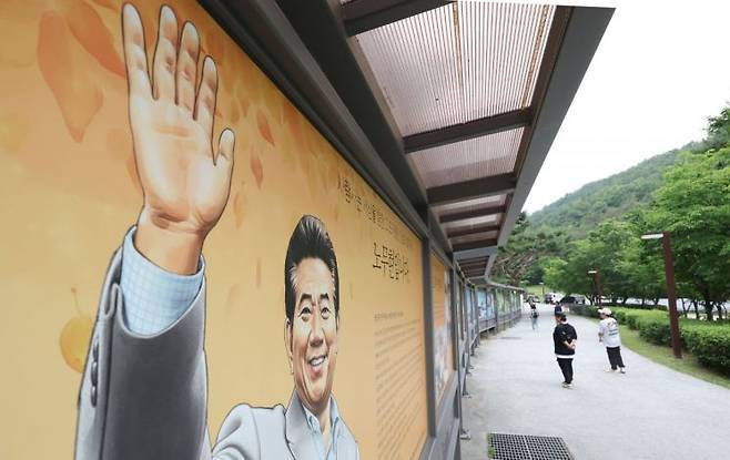 노무현 전 대통령 서거 16주기 추도식을 하루 앞둔 22일 경남 김해시 진영읍 봉하마을에서 시민이 노 전 대통령 사진을 보고 있다. 연합뉴스