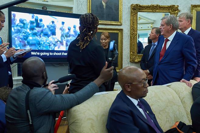 5월 21일 워싱턴 백악관 집무실에서 도널드 트럼프 대통령과 시릴 라마포사 남아공 대통령이 회담하는 동안  트럼프 대통령이 남아공의 백인 농부 학살 증거라고 주장한 영상을 재생하고 있다./AP 연합뉴스