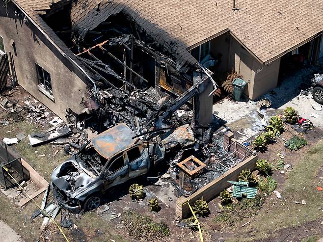 22일(현지 시각) 소형 비행기가 미국 캘리포니아주 샌디에이고 인근 지역에 추락해 집과 차량에 불이 붙은 후 잔해가 땅을 덮고 있다. /AP=연합뉴스