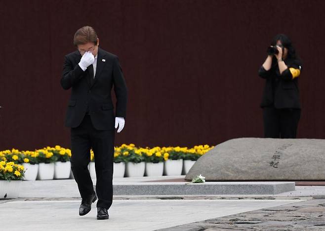 더불어민주당 이재명 대선 후보가 23일 경남 김해시 진영읍 봉하마을을 방문해 노무현 전 대통령 묘역을 참배한 뒤 돌아서며 눈물을 훔치고 있다. ⓒ연합뉴스