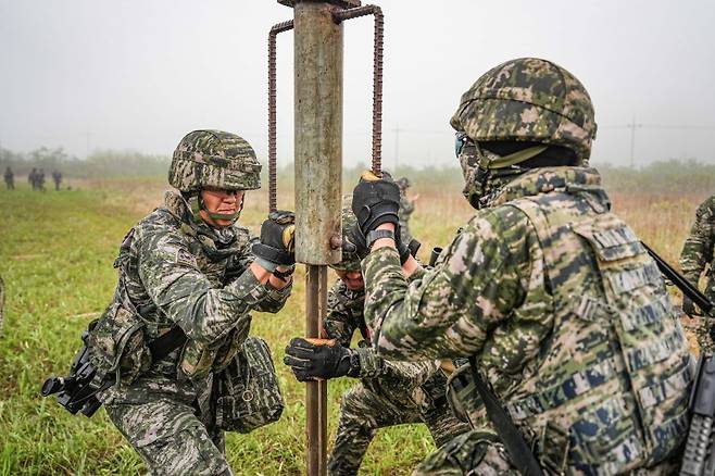 서북도서방위사령부는 지난 21일부터 23일까지 백령도와 연평도 등 서북도서 일대에서 서북도서의 군사대비태세를 유지하고, 합동작전 수행능력을 향상하기 위해 2025년 전반기 합동도서방어훈련을 실시했다.사진은 21일 해병대 6여단 장병들이 합동도서방어훈련 간 백령도 지역에 적 강점에 대비하여 철조망 장애물을 설치하고 있다. 해병대사령부 제공
