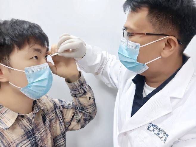 연구진이 적외선을 가시광선으로 바꿔주는 렌즈를 눈에 끼우고 있다. 중국과학기술대 제공