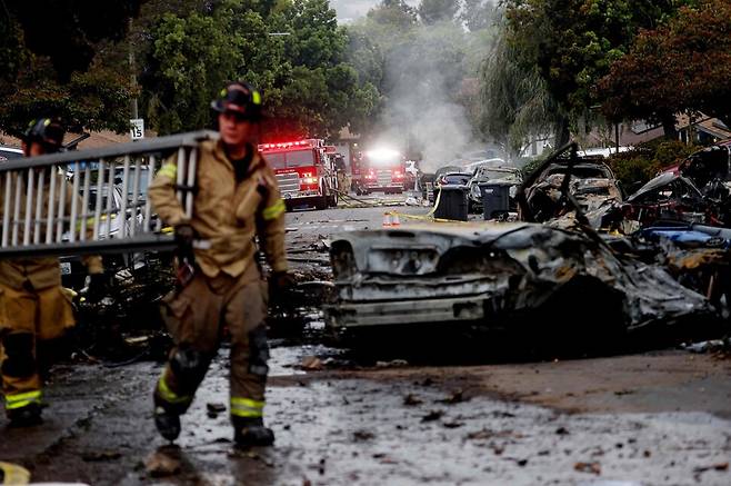 소방대원들이 22일(현지시각) 미 샌디에이고 소형비향기 추락사고 현장에서 작업을 벌이고 있다. 샌디에이고/AFP 연합뉴스