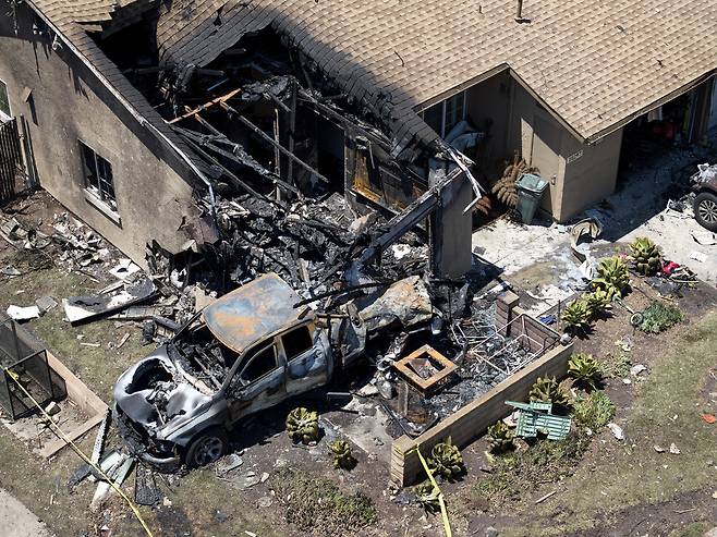22일(현지시각) 미 샌디에이고 주택단지에서 발생한 소형비행기 추락사고로 주택과 차량이 불에 타 파손돼 있다. 샌디에이고/AP 연합뉴스