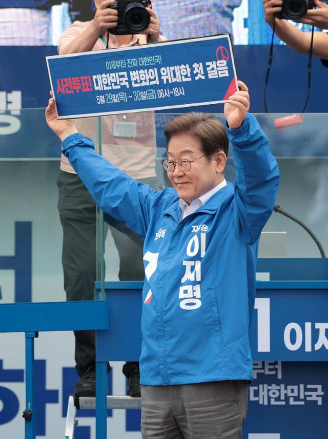 이재명 더불어민주당 대선 후보가 22일 경남 양산시 양산워터파크공원에서 열린 집중유세에서 사전투표 독려 손팻말을 들어 보이 있다. "대통령께서 우리 곁은 떠나신 지 어느덧 16년이 흘렀다. 시간이 흘렀지만 오늘 이 자리에 모인 우리 모두는 아직도 당신을 떠나보내지 못한 채 미완의 꿈을 붙잡고 있다"며 이같이 적었다.