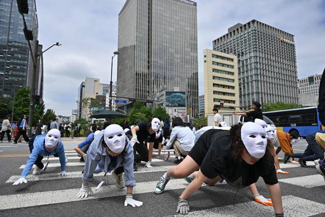 무용수와 시민 등 50여 명이 22일 서울 광화문 이순신동상 앞에서 네 발로 횡단보도를 건너며 자연과 인간의 공생을 강조하는 퍼포먼스를 하고 있다. 정다빈 기자 answer@hankookilbo.com