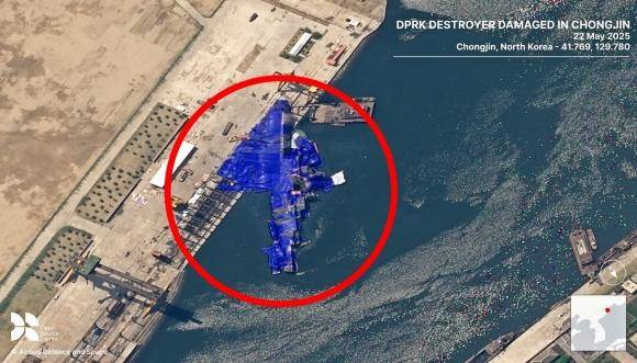 영국의 비영리 안보연구기관 오픈소스센터(OSC)가 22일 X를 통해 진수식에서 파손된 북한 신형 5,000톤급 구축함 사진을 공개했다. 함수는 육지에, 함미는 물에 있는 채로 파란색 거적이 덮혀 있다. OSC X 캡쳐.