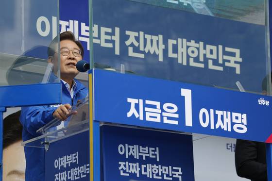 Democratic Party presidential candidate Lee Jae-myung speaks behind bulletproof glass during a campaign event in Paju, Gyeonggi, on May 20. [NEWS1]