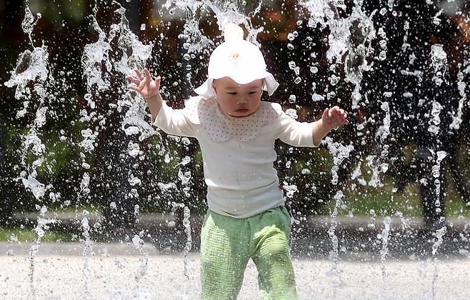대구 낮 최고기온이 33도까지 오르며 무더운 날씨를 보인 20일 대구 서구 평리공원 바닥분수에서 아기가 물놀이를 하고 있다. 뉴시스