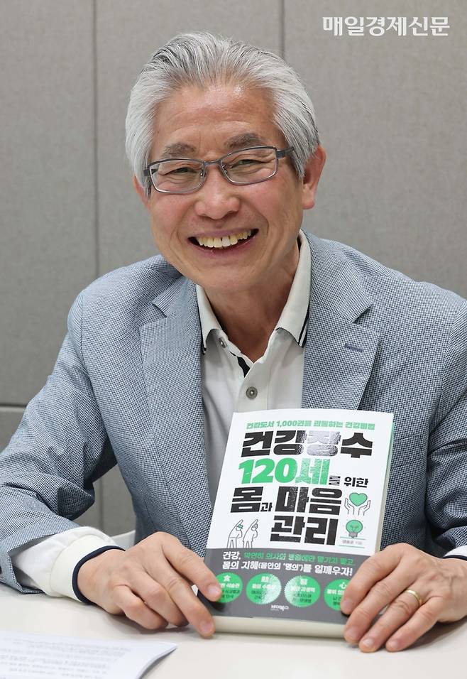 염용운 대표가 자신이 최근 출간한 저서인 ‘건강 장수 120세를 위한 몸과 마음 관리’를 보여주며 활짝 웃고 있다. 한주형 기자