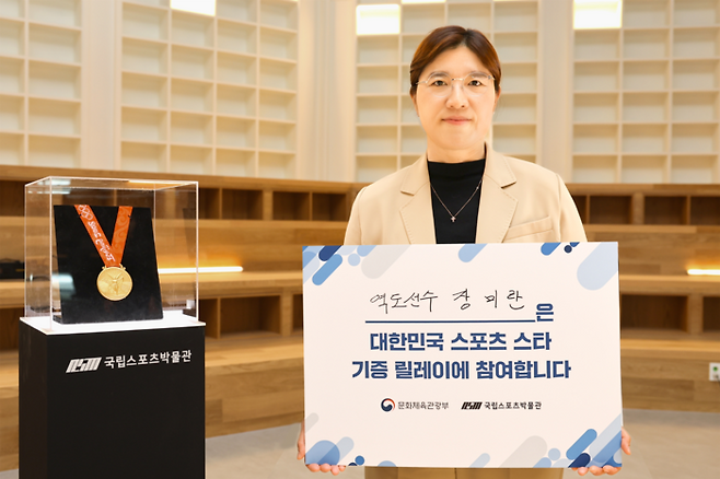 장미란 문체부 2차관이 국립스포츠박물관에 2008년 베이징올림픽 금메달을 기증하고 포즈를 취하고 있다. 문화체육관광부