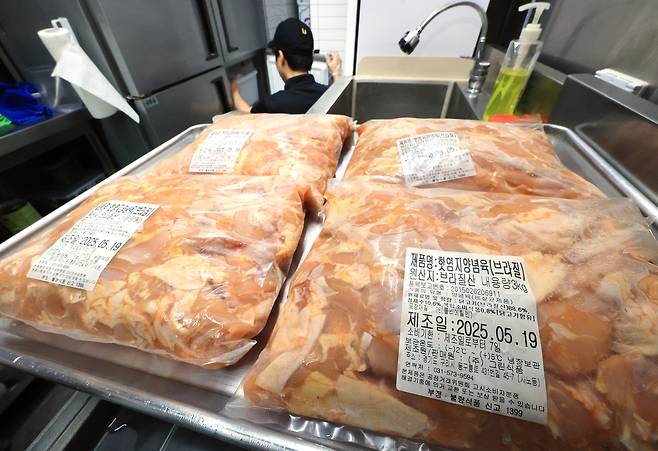 서울 시내 한 치킨판매점에서 점주가 냉장고에 있는 재고를 점검하고 있다.  [연합]