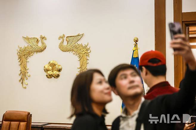 [서울=뉴시스] 정병혁 기자 = 9일 서울 종로구 청와대를 찾은 관람객들이 본관 대통령 집무실에서 사진을 찍고 있다. 윤석열 전 대통령에 대한 헌법재판소의 탄핵 선고 후 청와대를 찾는 발길이 늘어나고 있다. 광화문 등 인근에서 이어지던 탄핵 시위가 멈춘 데다, 조기 대선 후 대통령 집무실의 청와대 복귀 가능성도 나오는데 따른 변화로 읽힌다. 2025.04.09. jhope@newsis.com