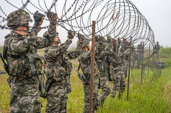 [서울=뉴시스] 서북도서방위사령부는 지난 21일부터 23일까지 백령도와 연평도 등 서북도서 일대에서 서북도서의 군사대비태세를 유지하고, 합동작전 수행능력을 향상하기 위해 2025년 전반기 합동도서방어훈련을 실시했다.사진은 21일 해병대 6여단 장병들이 합동도서방어훈련 간 백령도 지역에 적 강점에 대비하여 철조망 장애물을 설치하고 있다. (사진=해병대사령부 제공) 2025.05.23. photo@newsis.com *재판매 및 DB 금지