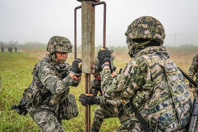 [서울=뉴시스] 서북도서방위사령부는 지난 21일부터 23일까지 백령도와 연평도 등 서북도서 일대에서 서북도서의 군사대비태세를 유지하고, 합동작전 수행능력을 향상하기 위해 2025년 전반기 합동도서방어훈련을 실시했다.사진은 21일 해병대 6여단 장병들이 합동도서방어훈련 간 백령도 지역에 적 강점에 대비하여 철조망 장애물을 설치하고 있다. (사진=해병대사령부 제공) 2025.05.23. photo@newsis.com *재판매 및 DB 금지