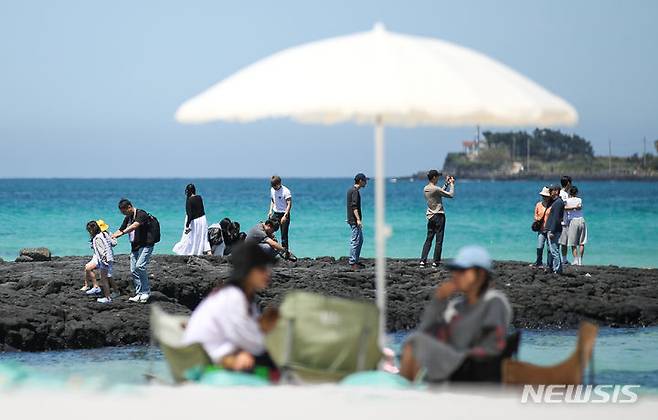 [제주=뉴시스] 우장호 기자 = 맑은 날씨를 보인 25일 오후 제주시 한림읍 협재해수욕장을 찾은 관광객들이 시원한 바닷바람을 쐬며 즐거운 시간을 보내고 있다. 2024.04.25. woo1223@newsis.com