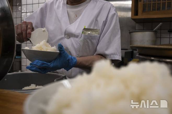 [도쿄=AP/뉴시스]지난 22일 일본 도쿄의 한 식당에서 직원이 밥을 그릇에 담고 있다. 2025.05.23.