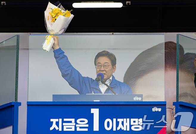 이재명 더불어민주당 대통령 후보가 24일 오후 경기도 안산시 단원구 안산문화광장에서 세월호 참사 유족에게 프라지아 선물 받은 '프라지아' 꽃을 들어보이고 있다. 2025.5.24/뉴스1 ⓒ News1 이재명 기자