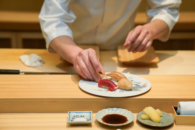 Chef Tamaru Mitsuhiro preparing a piece of sushi for a guest. /Grand InterContinental Seoul Parnas