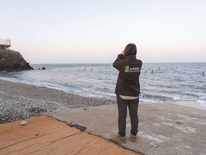 박 단장이 백령도 하늬바다에서 쌍안경으로 점박이물범을 관찰하고 있다. 과학동아 제공