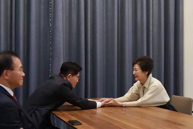 김문수 후보가 24일 박 전 대통령과 마주 앉아 두 손을 맞잡고 인사를 나누고 있다. 박 전 대통령은 웃으며 화답했다. (국민의힘)