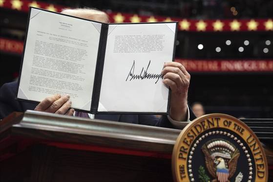 트럼프 대통령이 취임 당일인 1월 20일 미국 워싱턴DC에서 서명을 마친 행정명령을 들어보이고 있다. DEI 폐기도 하나였다. [AP=연합뉴스]