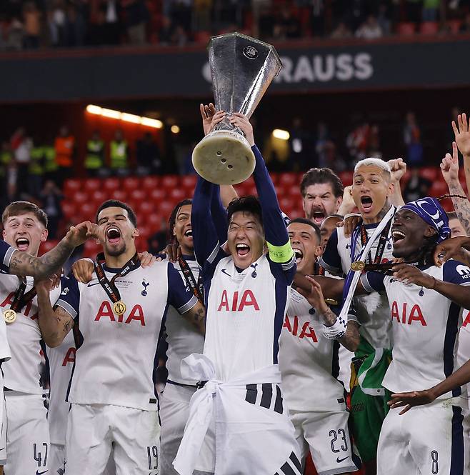 <‘우승’ 빈칸 채운 손흥민 “나도 전설”>  토트넘의 ‘캡틴’ 손흥민(가운데)이 22일 스페인 빌바오의 산 마메스 경기장에서 열린 2024~2025 유럽축구연맹(UEFA) 유로파리그(UEL) 결승에서 맨체스터 유나이티드를 꺾은 뒤 태극기를 허리에 두르고 우승 트로피를 들어올리고 있다. 로이터연합뉴스