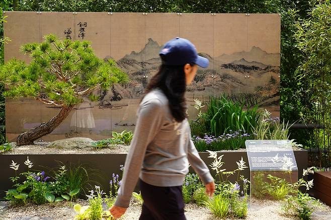 A visitor takes a quick look at Gangseo-gu's garden displayed at Seoul International Garden Show 2025 in Dongjak-gu, southwestern Seoul, Wednesday. (Lee Si-jin/The Korea Herald)