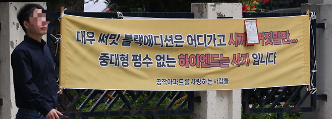 23일 서울시가 소셜믹스 정책의 일환으로 공개 추첨방식 주택 배치, 소형 평형 추가 확보 등을 여의도 공작아파트 조합에 요구하자 주민들이 이에 반발해 현수막을 붙인 모습. [한주형 기자]