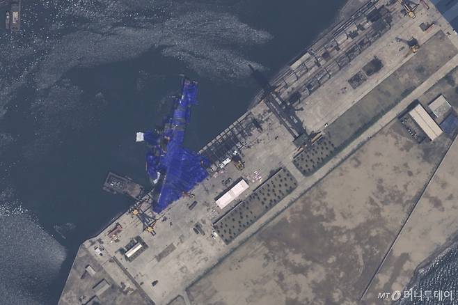 [청진=AP/뉴시스] 에어버스 DS가 제공한 22일 자 위성 사진에 북한 청진의 조선소에서 진수에 실패한 5000t 최현급 신형 구축함이 파란 방수포에 덮여 있다. 2025.05.23. /사진=민경찬