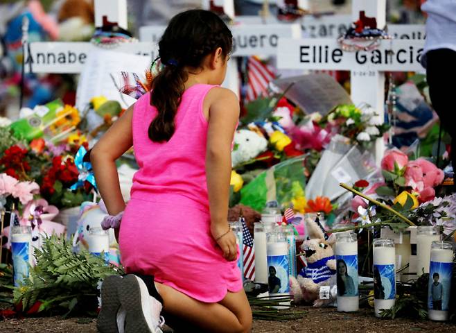미국 텍사스주 유밸디에 위치한 롭 초등학교에서 21명의 목숨을 앗아간 총기 난사 사건이 벌어졌다. 사진은 2022년 5월28일 롭 초등학교 추모식에서 한 소녀가 무릎을 꿇고 희생자들을 추모하며 기도하는 모습. /사진=로이터