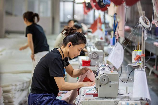 지난 15일(현지시간) 중국 동부 장쑤성 난퉁에 위치한 섬유 공장에서 직원들이 가정용 섬유를 생산하고 있다.  해당 사진은 기사와 직접적 관련 없음. [AFP]