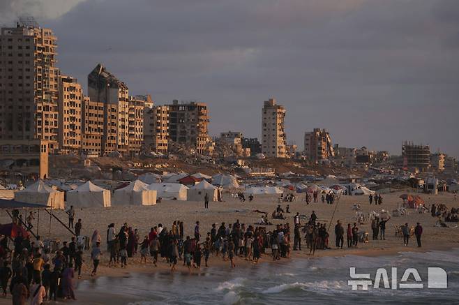 [가자시티=AP/뉴시스] 지난 22일(현지 시간) 가자지구 가자시티 해안에 조성된 천막촌 주변 해변에 팔레스타인 피란민들이 모여 있다. 프랑스, 사우디아라비아, 이집트, 요르단이 내달 유엔에서 '두 국가 해법'을 논의하는 방안을 추진 중이다. 2025.05.24.