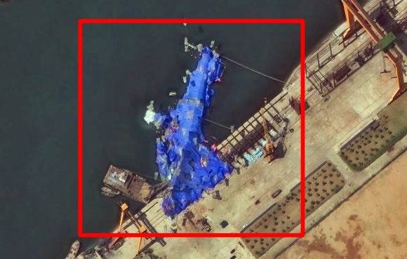23일(현지시간) 미국 민간위성업체 ‘맥사 테크놀로지’가 제공한 위성 사진. 북한 함경북도 청진시 청진조선소에서 전복된 새 구축함이 파란색 방수포로 덮여 있다. 2025.5.24 EPA 연합뉴스(맥사 테크놀로지 제공)