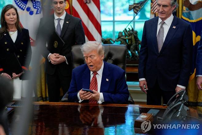 스마트폰 보는 트럼프 [워싱턴 로이터=연합뉴스. 재판매 및 DB 금지]