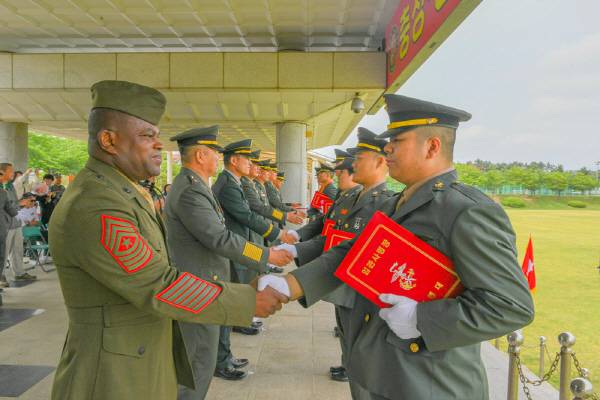 해병대 교육훈련단이 지난 23일 행사 연병장에서 해병 부사관 410기 86명을 새로이 배출한 가운데 참석한 군 관계자가 신임 부사관과 악수하는 모습. 해병대 교육훈련단 제공
