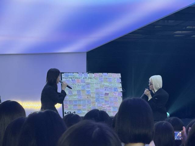 가수 자이언티(오른쪽)가 기아 디스커버리 데이 토크 세션에서 '마음을 움직이는 에너지'에 대한 방문객들의 메시지를 읽고 있다.