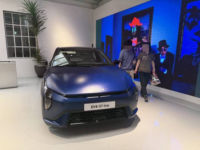 방문객들이 행사장에 전시된 기아의 첫 전기 세단 EV4 GT-라인을 둘러보고 있다.