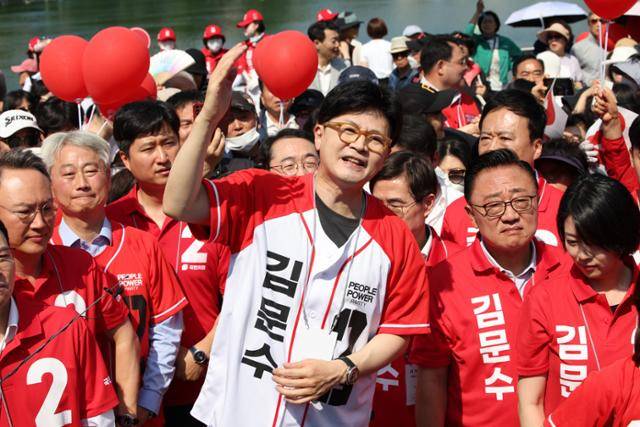 한동훈 전 국민의힘 대표가 25일 서울 송파구 석촌호수에서 김문수 국민의힘 대선 후보 지지를 호소하고 있다. 한 전 대표가 '김문수' 이름이 새겨진 선거운동복을 입은 것은 이날이 처음이다. 뉴시스