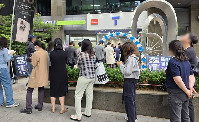 People line up outside an SK Telecom store in Seoul to exchange their USIM cards on Tuesday. (Yonhap)
