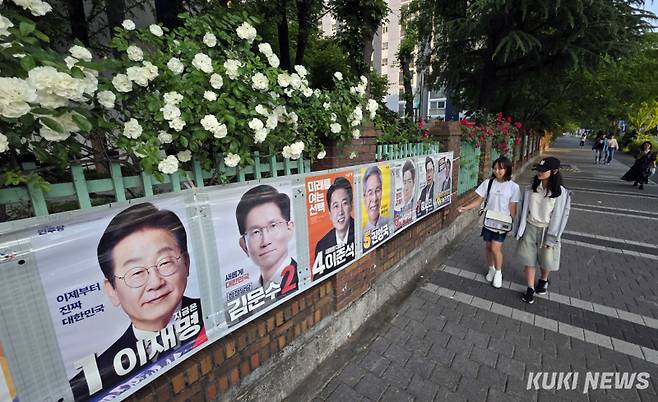 &nbsp;“이번에는 누가 대통령이 될까?”25일 대전광역시 서구 둔산동의 한 아파트 담장에 만개한 장미꽃 아래 예비 유권자인 어린 학생들이 제21대 대통령 선거 벽보를 살펴보고 있다.&nbsp;