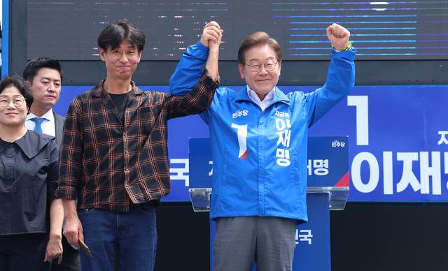 이재명 더불어민주당 대선 후보가 22일 제주시 일도일동 동문로터리에서 열린 유세에서 배우 박혁권와 함께 지지자들에게 인사를 하고 있다. 연합뉴스