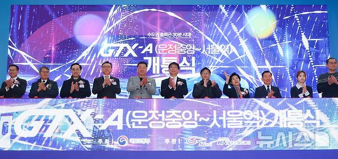 [파주=뉴시스] 황준선 기자 = 박상우(왼쪽 여섯 번째) 국토교통부 장관과 내빈들이 27일 오후 경기 파주시 운정중앙역에서 열린 GTX-A 운정중앙-서울역 구간 개통식에서 기념 세리머니를 하고 있다. 2024.12.27. hwang@newsis.com