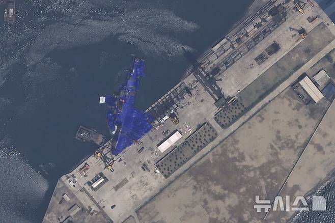 [청진=AP/뉴시스] 에어버스 DS가 제공한 22일 자 위성 사진에 북한 청진의 조선소에서 진수에 실패한 5000t 최현급 신형 구축함이 파란 방수포에 덮여 있다. 2025.05.25.