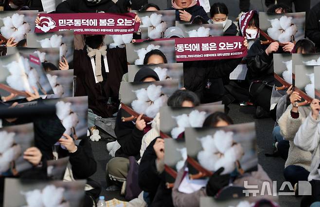 [서울=뉴시스] 이영환 기자 = 동덕여대재학생연합 소속 학생 등이 3일 오후 서울 종로구 북인사마당 인근에서 진행된 동덕여대 재단 규탄 집회에서 교화인 목화 피켓을 들고 구호를 외치고 있다.  2025.03.03. 20hwan@newsis.com