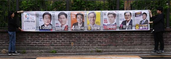 15일 서울 종로구 동숭동 예술가의집 담장에 서울시선거관리위원회 관계자들이 제21대 대통령 선거 벽보를 붙이고 있다. 2025.5.15. 안주영 전문기자
