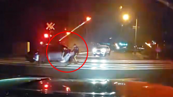 미국 뉴저지주 피스카타웨이에 있는 한 건널목에서 열차 진입 직전 건널목에 있던 차량 운전자를 구조하는 경찰의 모습이 포착됐다. 피스카타웨이 경찰서 제공