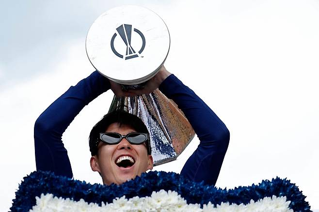 손흥민이 23일 영국 토트넘 경기장에서 열린 우승 퍼레이드에 참여해 유로파리그 우승컵을 들어올리고 있다. AFP