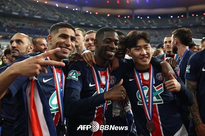 파리 생제르맹(PSG) 이강인(오른쪽)이 25일 2024~2025 프랑스 쿠프 드 프랑스 우승 메달을 목에 걸고 우스만 뎀벨레 등 동료들과 사진을 찍고 있다. /AFPBBNews=뉴스1