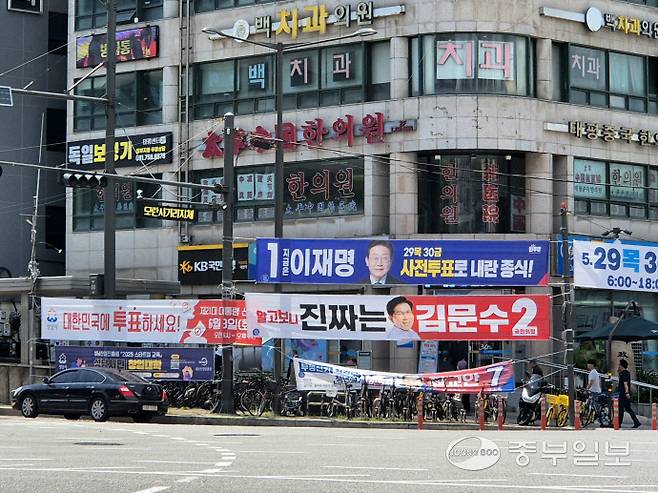 26일 성남시 수정구 수진동 태평역 사거리 내 빨간색 디자인이 적용된 투표 독려 현수막. 해당 현수막 옆으로 유사한 디자인의 김문수 국민의힘 후보 현수막이 걸려 있다. 강현수기자